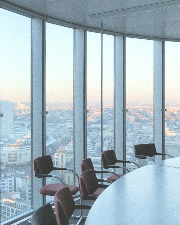 Sala de consejo en una torre, con la ciudad al fondo