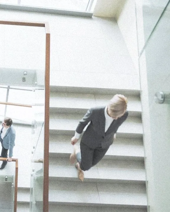 Directivos cruzándose en una escalera de vidrio